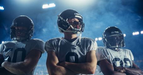 Portrait of Three Diverse Athletic Football Players Standing Confidently on the Field, Posing Crossed Arms and Looking at Camera. Professional Footballers Before a Championship Game