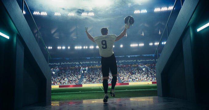 Successful Star Player in White Uniform Walking Out of the Stadium Tunnel Before a Championship Match. Talented American Football Player is Cheered by the Sports Fans at a Professional Stadium