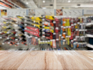 Wooden table top (counter bar) with blured Hand tools on shelf display at store for background. Banner for advertise on online media. For montage product display visual layout. Shopping concepts.