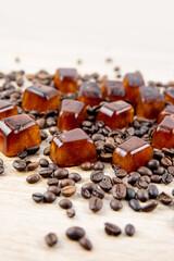 Side view of coffee ice cuber scattered on table, decorated with coffee beans. Studio shot. Concept of coffee ice cubes for making iced coffee.
