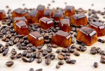 Side view of coffee ice cuber scattered on table, decorated with coffee beans. Studio shot. Concept of coffee ice cubes for making iced coffee.