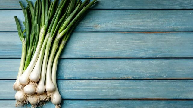Fresh scallions on light blue wooden surface, perfect for cooking recipes, displaying food ingredients, and adding to healthy lifestyle promotions