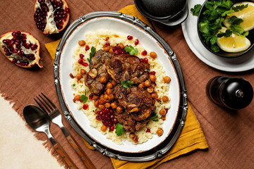 Top view of Moroccan style Lamb and  Chickpea Stew, served with pomegranate, coriander and couscuos.
