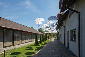 white umbrellas hanging  between houses