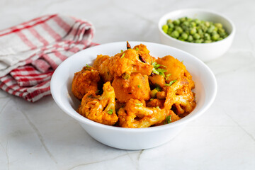 Aloo Phulkopir Dalna is a Bengali potato and cauliflower curry, cooked with spices, tomatoes, and ginger in a rich gravy.