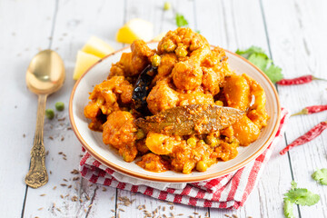 Aloo Phulkopir Dalna is a Bengali potato and cauliflower curry, cooked with spices, tomatoes, and ginger in a rich gravy.