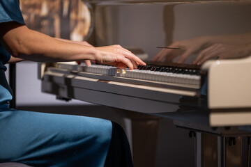 Female hands and white pianoforte keys