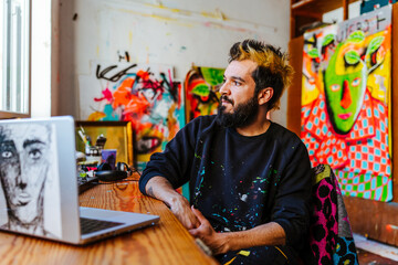 Artist Reflecting in His Studio Surrounded by Paintings. An Argentine artist sits at his workspace,...