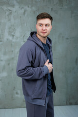 A man with a full beard is wearing a stylish grey hoodie today