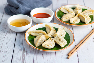 Momo are steamed or fried dumplings filled with meat or vegetables, popular in Nepal, Tibet, and Bhutan, served with spicy chutney.