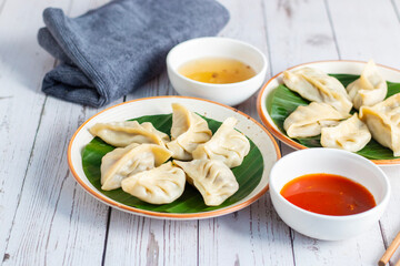 Momo are steamed or fried dumplings filled with meat or vegetables, popular in Nepal, Tibet, and Bhutan, served with spicy chutney.