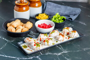 Dahi Bhalla is a popular Indian snack made of deep-fried lentil dumplings soaked in creamy yogurt, topped with tangy chutneys, spices, and pomegranate.