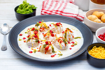 Dahi Bhalla is a popular Indian snack made of deep-fried lentil dumplings soaked in creamy yogurt, topped with tangy chutneys, spices, and pomegranate.