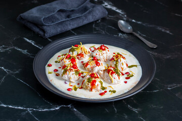 Dahi Bhalla is a popular Indian snack made of deep-fried lentil dumplings soaked in creamy yogurt, topped with tangy chutneys, spices, and pomegranate.