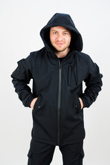 A man is wearing a black jacket that has a hood attached to it