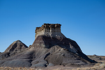 Im Vordergrund befindet sich ein Haufen aus r&ouml;tlich-braunem Material, bei dem es sich um Steine oder Erde handeln k&ouml;nnte, was das Gef&uuml;hl der H&auml;rte und nat&uuml;rlichen Kraft der Szene noch verst&auml;rkt. 