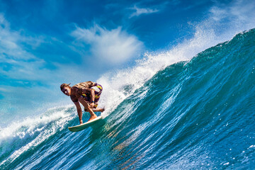 Male surfer on a blue wave at sunny day