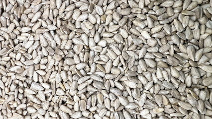 Peeled sunflower seeds are scattered in large quantities and randomly.