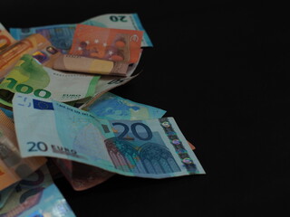 Euro bills are scattered chaotically on a black background. Protective elements are visible. There is a space for inserting text.