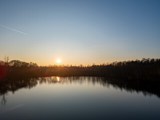 Obraz premium A breathtakingly peaceful sunset view over a calm lake, beautifully capturing the serene essence of nature