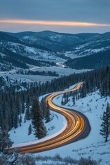 Winding mountain road in winter twilight with car light trails through snowy forest landscape and scenic valley view at dusk creating a peaceful and serene atmosphere