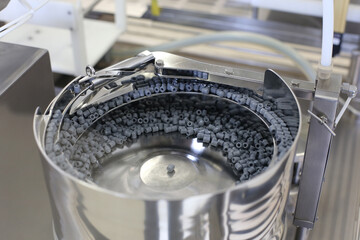 Bottling and packaging of sterile medical products. Stainless steel sorting pot with rubber stopper for syringes.