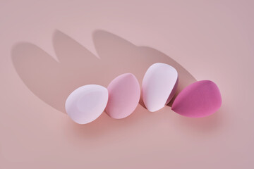 Fototapeta premium A set of makeup sponges on a pink background.