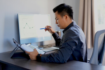 Busy young asian business man sales manager making phone call using laptop in office and talking on...