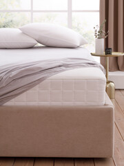 Bedroom with big window, wooden floor, double bed with mattress, covered by fitted sheet, two pillows and bedside table. Corner of mattress is visible. Front view close up photo. Suitable for mockup
