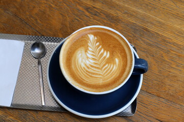 A cup of hot coffee on a table in a coffee shop