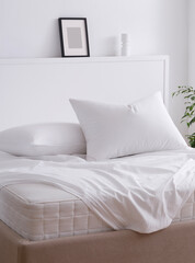Modern bedroom decorated with handmade furniture. Double bed with two pillows and white sheets elegantly draped over the mattress. Mattress corner is visible. Side view photo. Suitable for mockup
