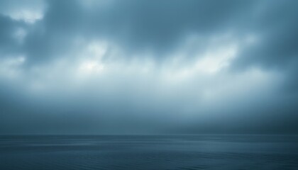 Dramatic Cloudy Sky Over Calm Water Creates Peaceful Coastal Landscape at Dusk