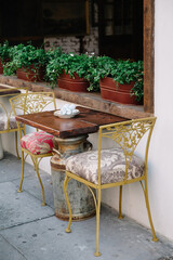 Cozy outdoor seating area with decorative chairs and plants in a charming city setting