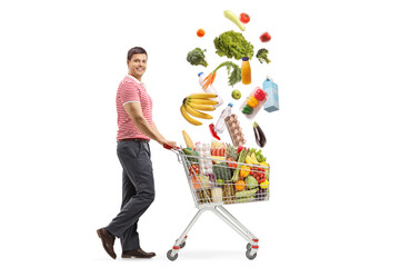 Man collecting falling food products with a shopping cart and smiling at the camera © Ljupco Smokovski