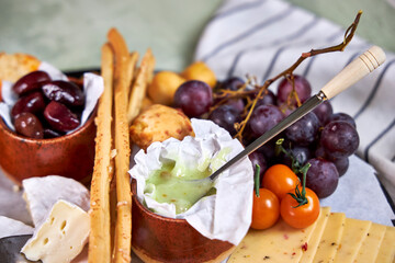 Close-up of a cheese plate with mild mold cheese, honey and olives
