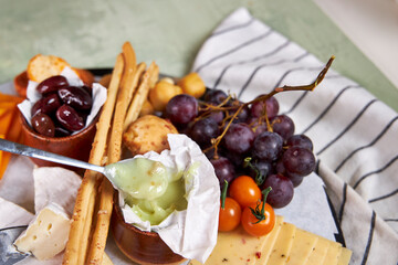 Close-up of a cheese plate with mild mold cheese, honey and olives