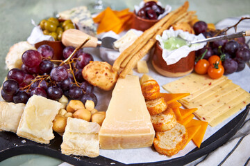 Close-up of a cheese plate with mild mold cheese, honey and olives