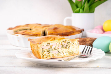 Easter Savory Pizza Pie, Traditional  Italian Easter cake pizza Rustica with ham, salami, ricotta cheese, eggs and spinach, on festive decorated table, copy space