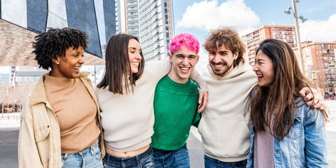 Happy multiracial group of friends walking on city street - Cheerful young people hanging outside...