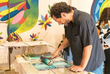 person painting with a roller, for the elaboration of an engraving, plastic artist, art, art,...