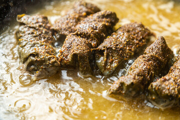 Homemade dolma with meat is stewed in a frying pan in broth