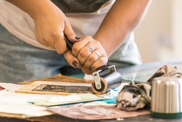 close up of hands using a roller painting an engraving, art, culture