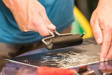 close up of hands with roller painting a picture for engraving, art, plastic artist, culture