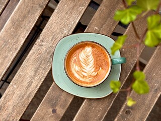 Top view of cappuccino with latte art on a rustic wooden table