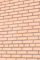 Brick wall background from the side with selective focus. Orange brick background for exterior design. Construction concept. Wall with classic checkerboard pattern and visible joints