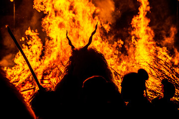 Silhouette of devil monster in front of a huge fire