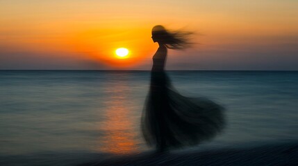 A blurred silhouette of a woman in a dress stands on a beach at sunset, with the sun setting over the ocean.