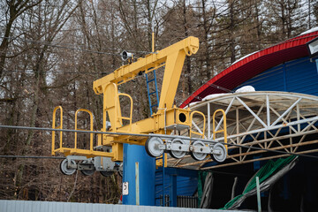 A bright yellow crane is prominently positioned right in front of a striking blue building, creating a striking visual contrast between the heavy machinery and the architecture