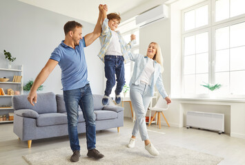 Fototapeta premium Cheerful parents enjoy leisure time at home, playing, laughing, and bonding with kid. A warm family moment filled with fun, entertainment, and shared happiness in a cozy domestic setting.