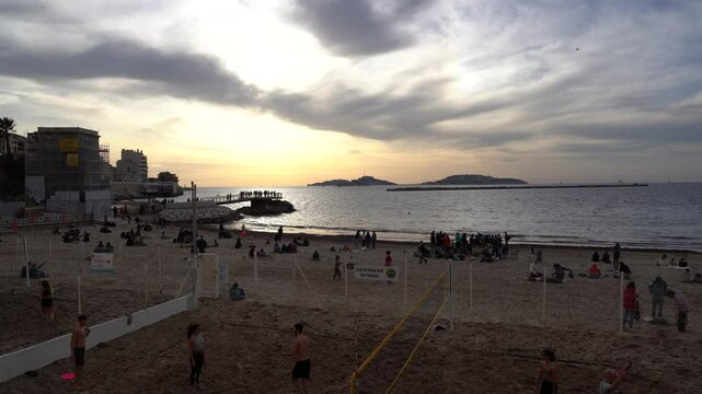 Marseille, France - February 2, 2025: View of Plage des Catalans. People relaxing on the beach and enjoying the sunset